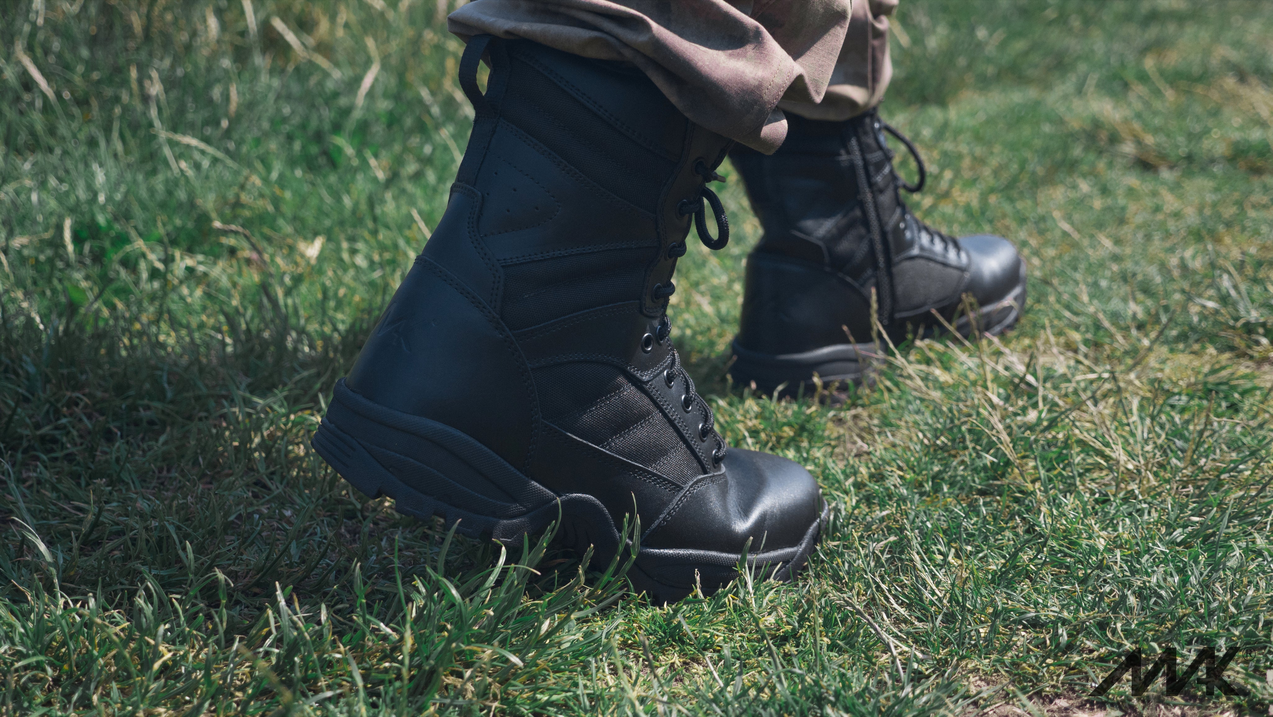 black leather boots walking through grass